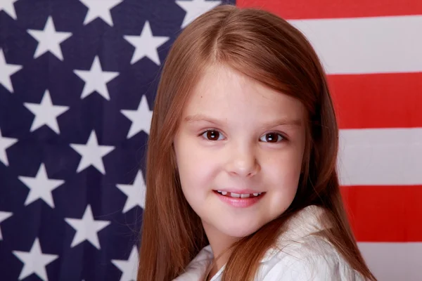 Menina contra o fundo da bandeira americana — Fotografia de Stock