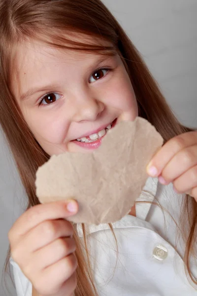 Girl holding a small paper heart — Stock Photo, Image