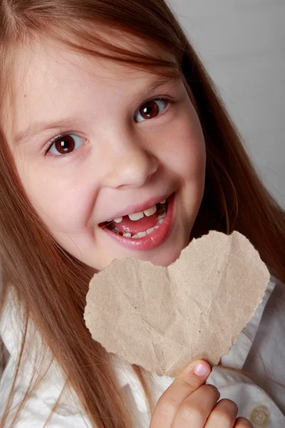 Girl holding a small paper heart — Stock Photo, Image