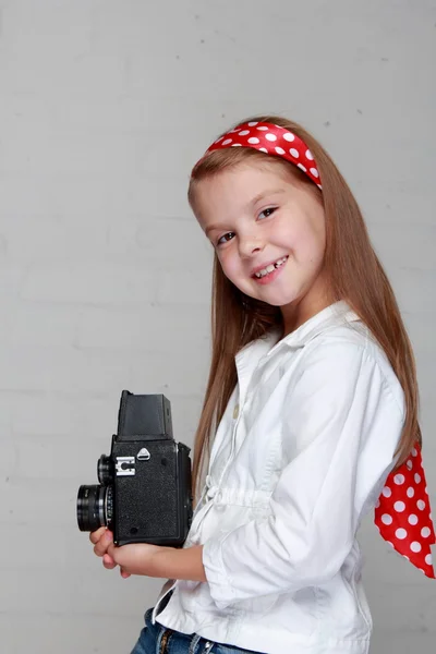 年轻女孩拿着一台老式的相机 — 图库照片