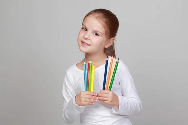 Pequena colegial segura um lápis — Fotografia de Stock