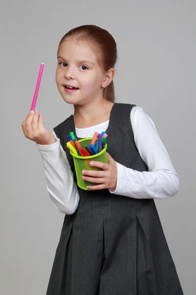 Schattige kleine schoolmeisje houdt een potlood — Stockfoto