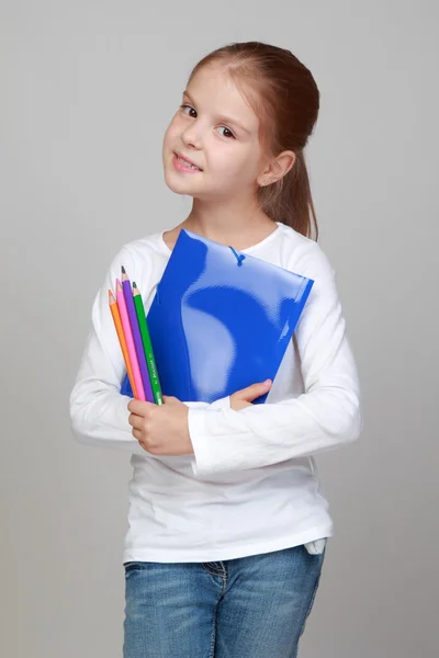 Девушка держит папку и карандаши — стоковое фото