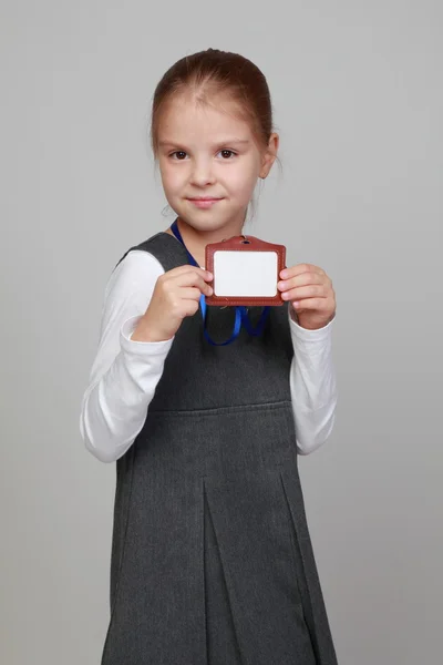 Girl in a school uniform with a badge — Stock Photo, Image