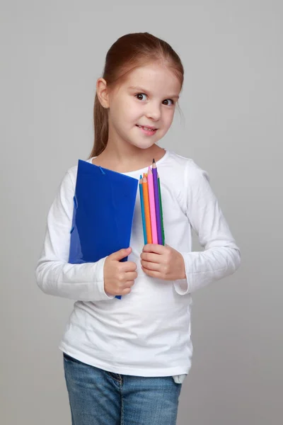 Girl holding a folder and color pencils — Stock Photo, Image