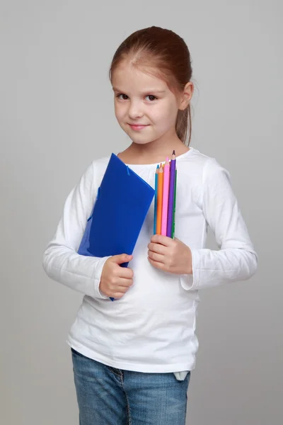 Bir klasör ve renkli kalem tutan kız — Stok fotoğraf