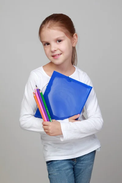 Dívka drží složku a tužky — Stock fotografie