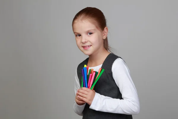 Menina segurando um monte de marcadores — Fotografia de Stock