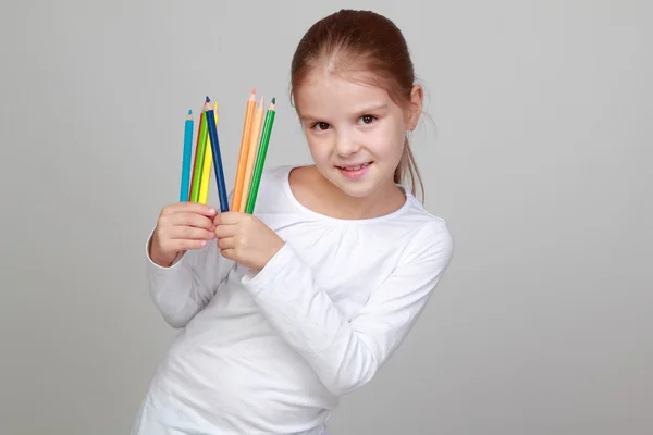 Pequena estudante segura um lápis — Fotografia de Stock