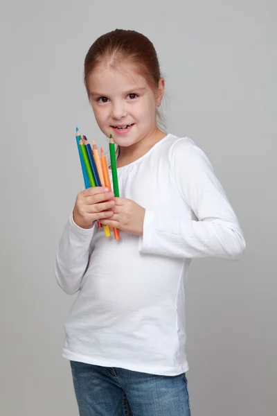Pequena estudante segura um lápis — Fotografia de Stock