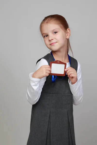 Menina com uma etiqueta de nome em branco — Fotografia de Stock