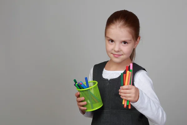 Petite écolière tient un crayon — Photo