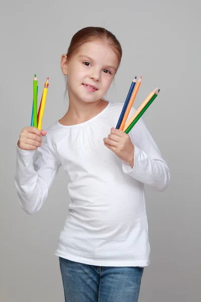 Pequena estudante segura um lápis — Fotografia de Stock