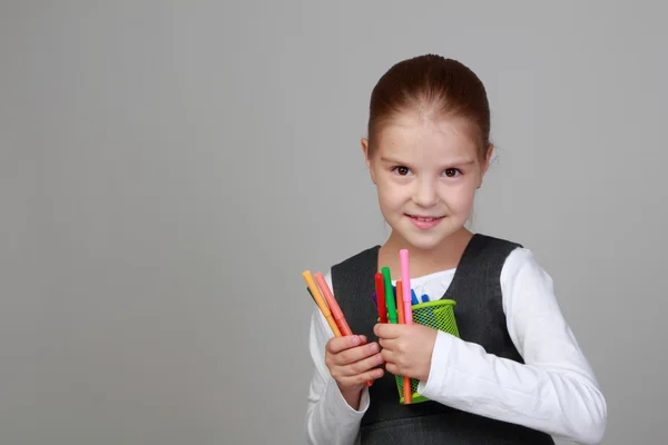 Pequeña colegiala sostiene un lápiz — Foto de Stock