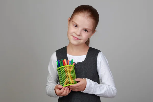 Petite écolière tient un crayon — Photo
