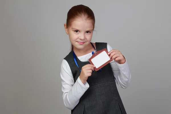 Girl in a school uniform with a badge — Stock Photo, Image