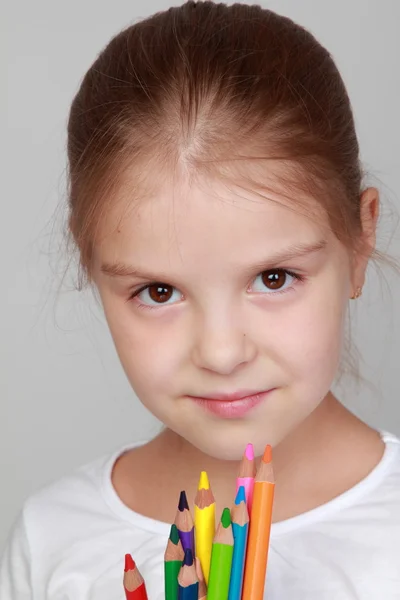 Kind hält viele Buntstifte in der Hand — Stockfoto