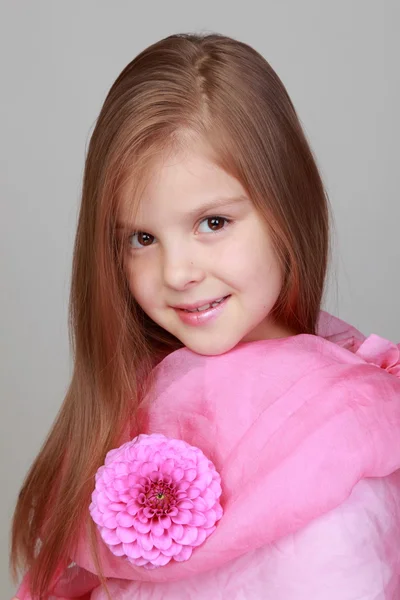 Ragazza in sciarpa rosa con in mano una dalie rosa — Foto Stock