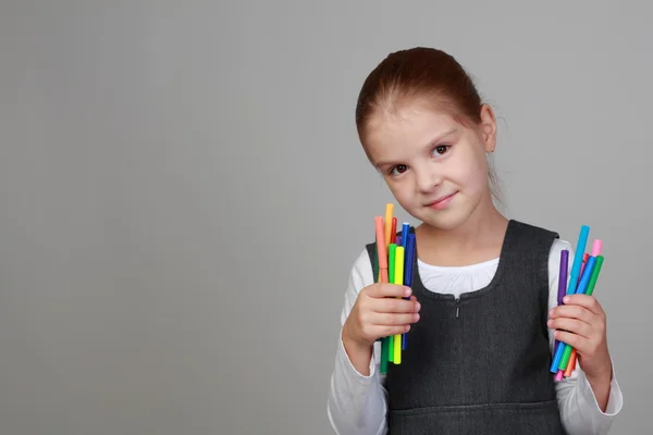 Schattig schoolmeisje houdt een potloden — Stockfoto