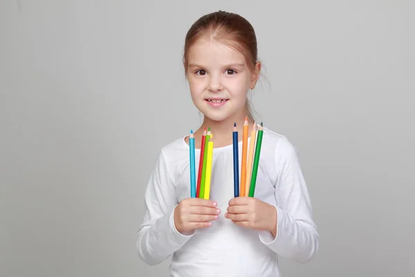 Child holds a lot of color pencils — Stock Photo, Image