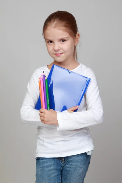 Meisje bedrijf mappen en potloden — Stockfoto