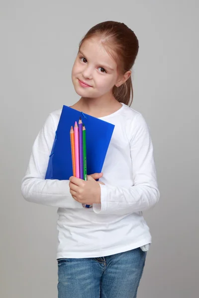 Menina segurando pastas e lápis — Fotografia de Stock