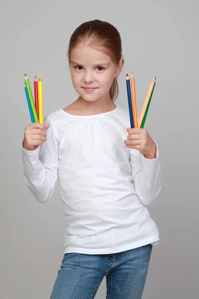 Schoolgirl holding pens for drawing — Stock Photo, Image