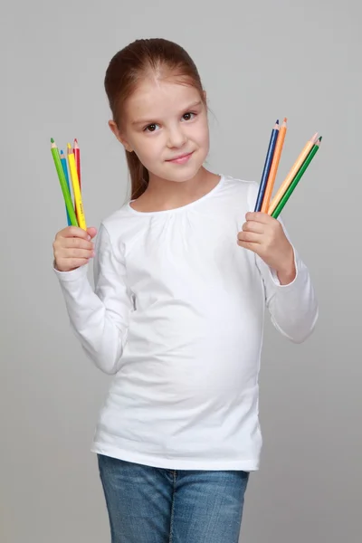 Schoolgirl holding pens for drawing — Stock Photo, Image