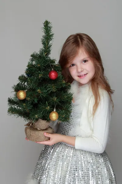 Девушка держит маленькую елку — стоковое фото