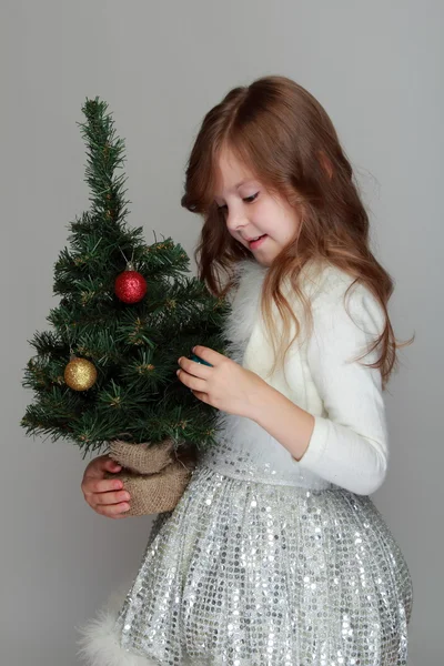Девушка держит маленькую елку — стоковое фото