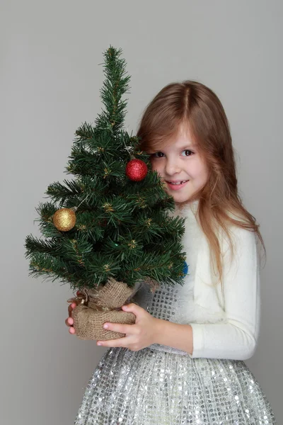 Meisje houdt van een kleine kerstboom — Stockfoto