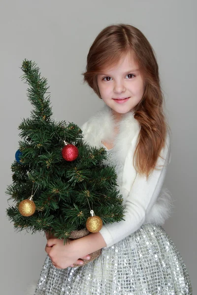 Girl holding a small Christmas tree — Stock Photo, Image