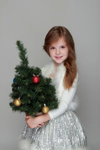 Girl holding a small Christmas tree — Stock Photo, Image