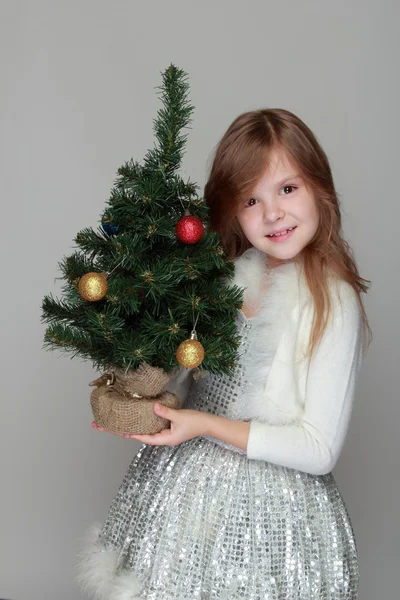 Dívka drží malý vánoční stromek — Stock fotografie