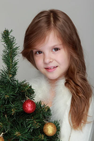 Flicka som håller en liten julgran — Stockfoto