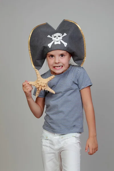 Fille dans un chapeau de pirate tenant une étoile de mer — Photo