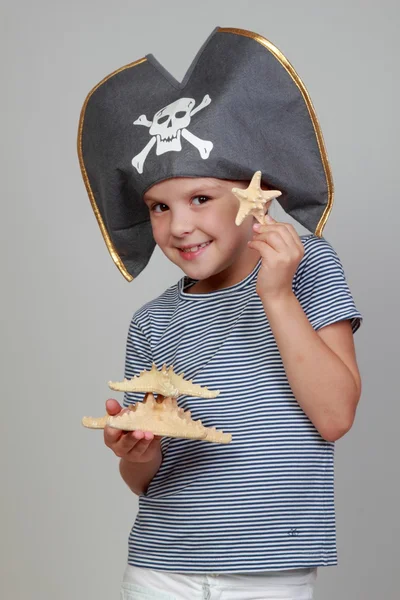 Chica en un sombrero pirata sosteniendo una estrella de mar — Foto de Stock