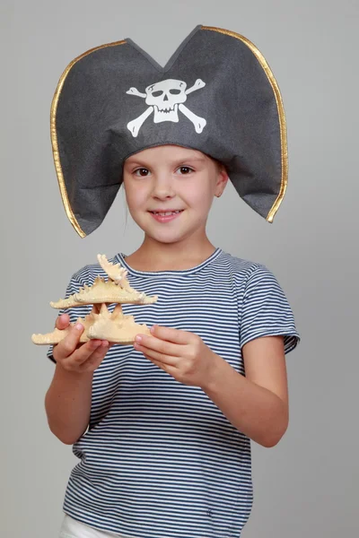 Chica en un sombrero pirata sosteniendo una estrella de mar — Foto de Stock