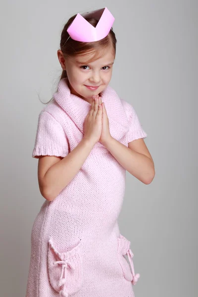 Child in a pink knitted dress with a pink crown — Stock Photo, Image