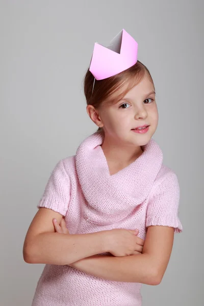 Ребёнок в розовом трикотажном платье с розовой короной — стоковое фото