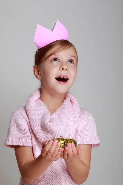 Criança em um vestido de malha rosa com uma coroa rosa — Fotografia de Stock