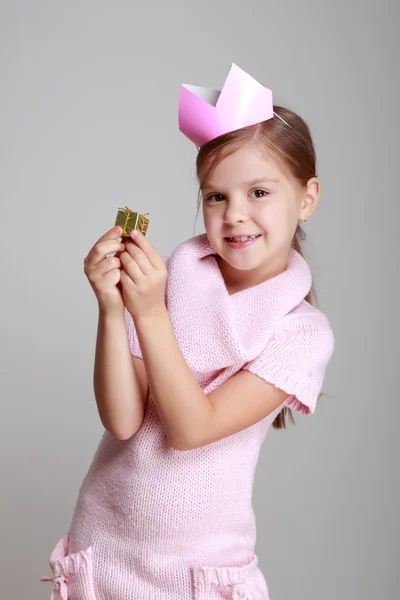 Criança em um vestido de malha rosa com uma coroa rosa — Fotografia de Stock