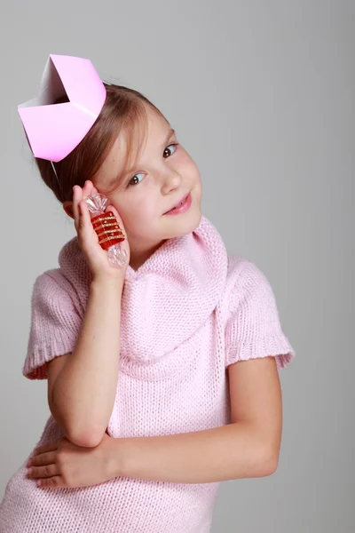 Kind in een roze gebreide jurk met een roze kroon — Stockfoto