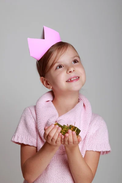 Criança em um vestido de malha rosa com uma coroa rosa — Fotografia de Stock