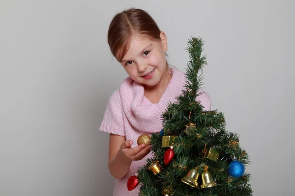 Kind neben einem geschmückten Weihnachtsbaum — Stockfoto