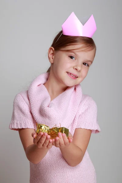 Criança em um vestido de malha rosa com uma coroa rosa — Fotografia de Stock