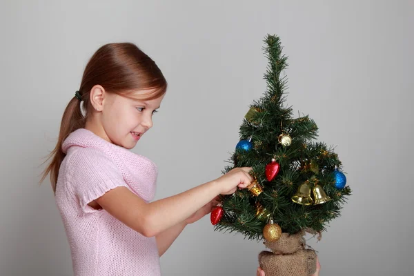 Kind in de buurt van een versierde kerstboom — Stockfoto
