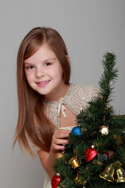 Menina com presente no fundo cinza — Fotografia de Stock