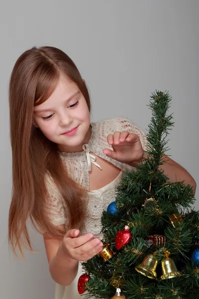 Chica sonriente cerca de un árbol de Navidad Imágenes De Stock Sin Royalties Gratis