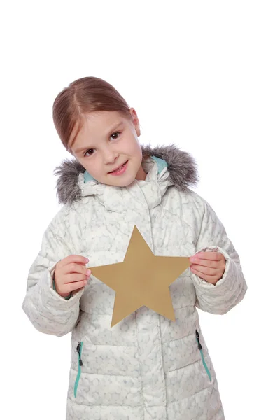 Girl in winter clothes holding a big gold star — Stock Photo, Image